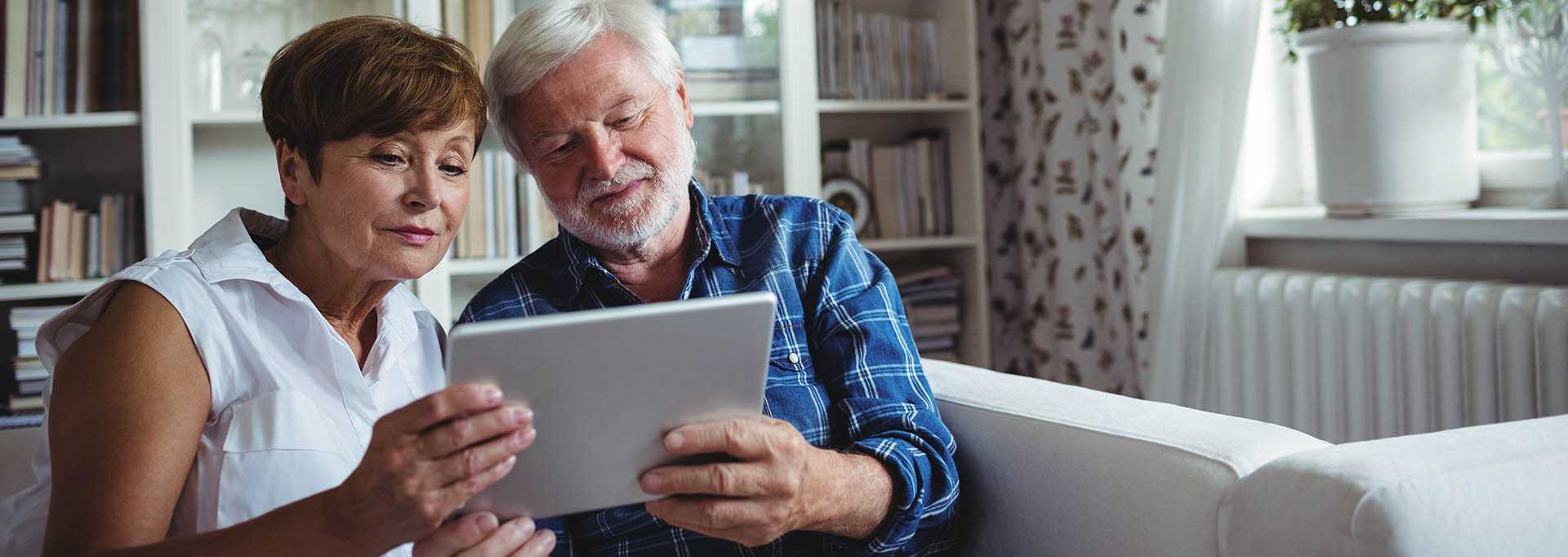 An older couple searching for care options on a tablet