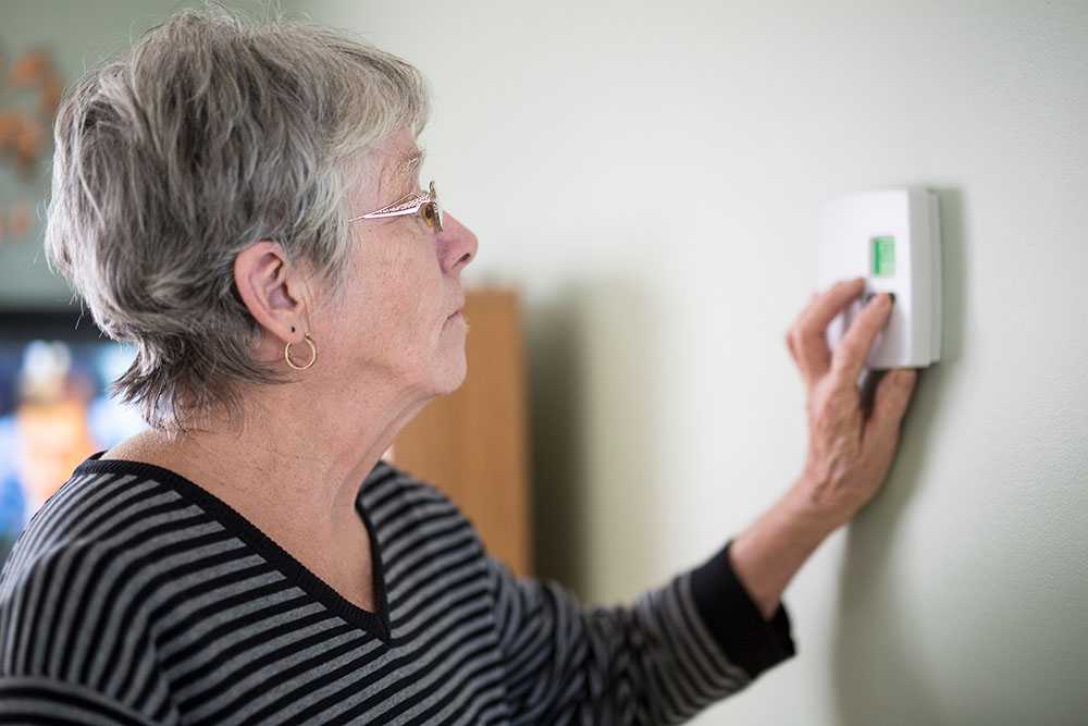 Winter fuel payment cuts with elderly woman turning dial