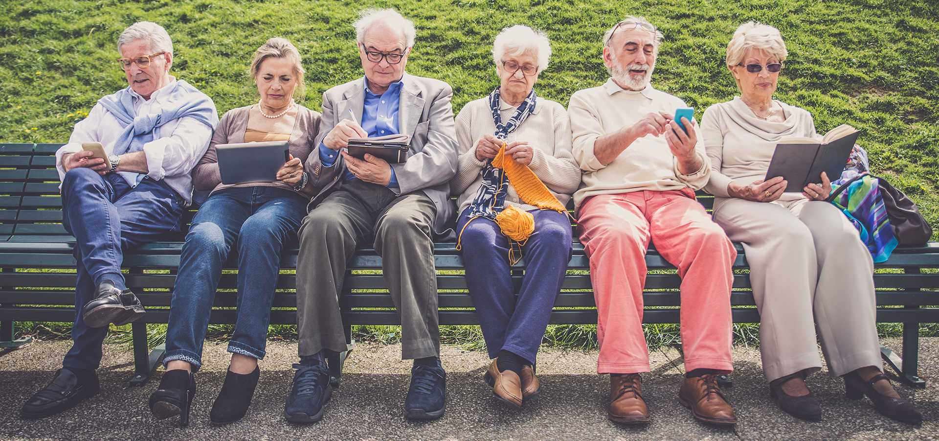 A number of retirement community residents sitting on a park bench