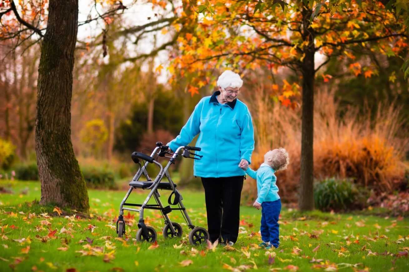 woman with her grandson, active older woman enjoying time with her grandchild in the garden of a care home