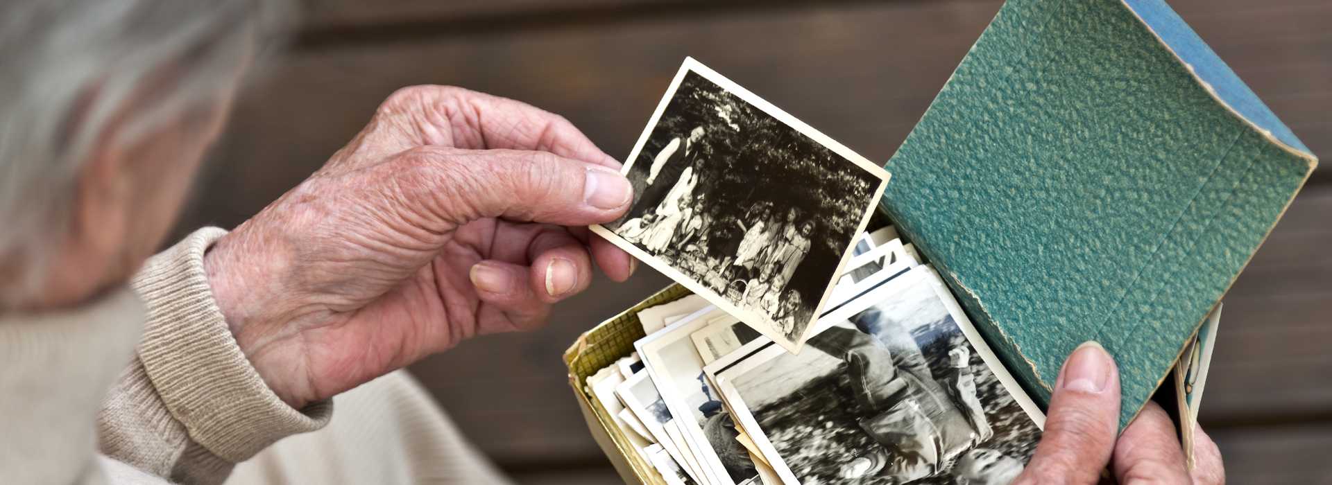 An elderly person sifting through old family photographs