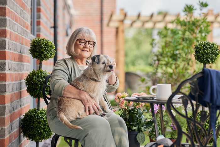 Woman sitting on a patio chair with her dog