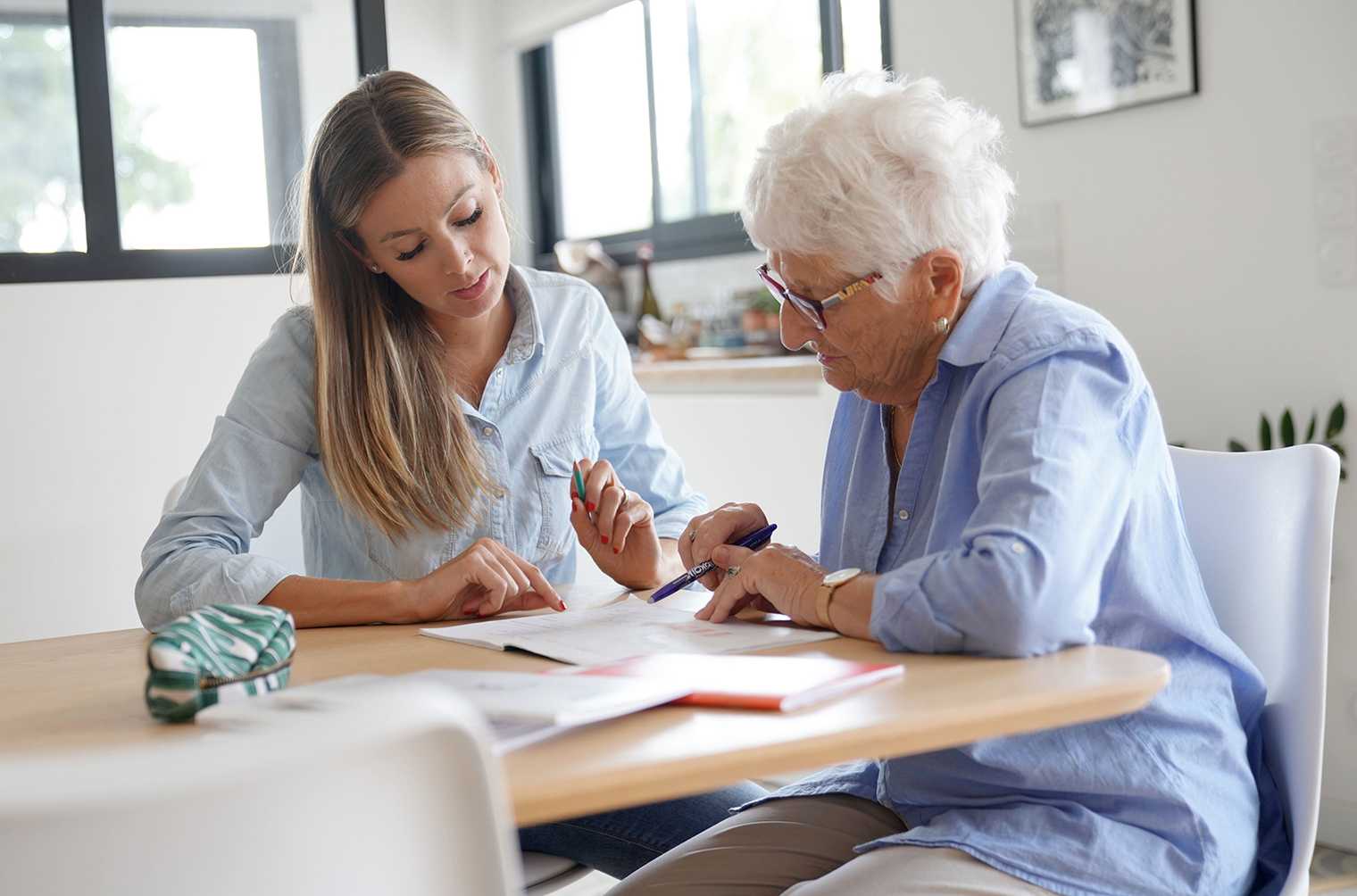 woman writing an advance care plan with a care professional