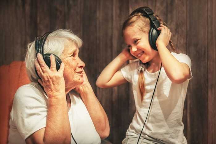 a woman with dementia enjoys music with her grandchild