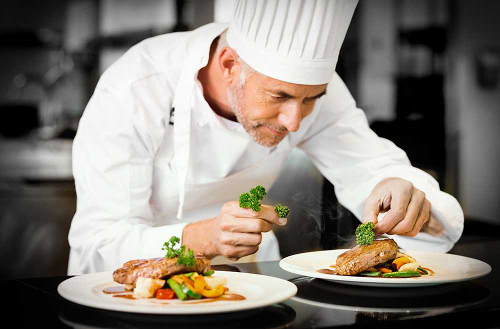 Chef with white hat preparing food in care homes