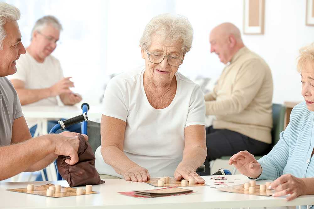 Picture showing a group of elderly people sitting around a table.